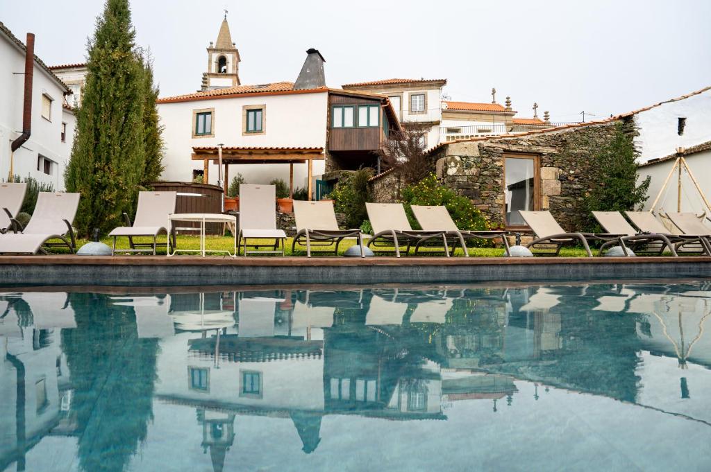 a swimming pool with lounge chairs and a house at Provesende Douro Villas - Casa Principal in Provesende