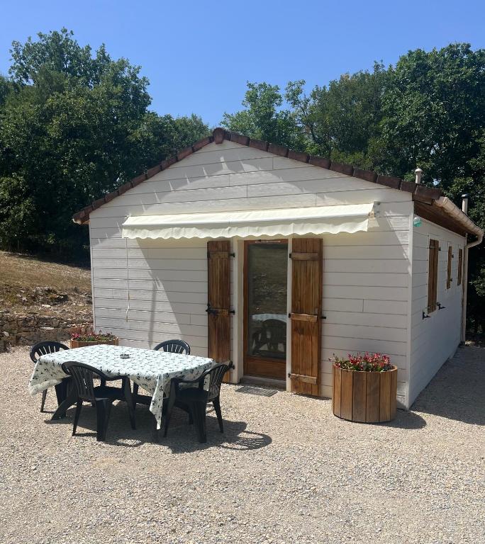 a small white shed with a table in front of it at Le petit coin du pêcheur in Brouchaud