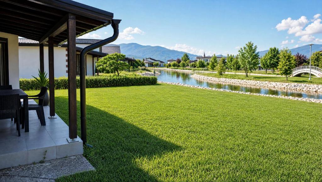 a yard with a river in the background at Sarajevo Resort Gestoria in Hadžići