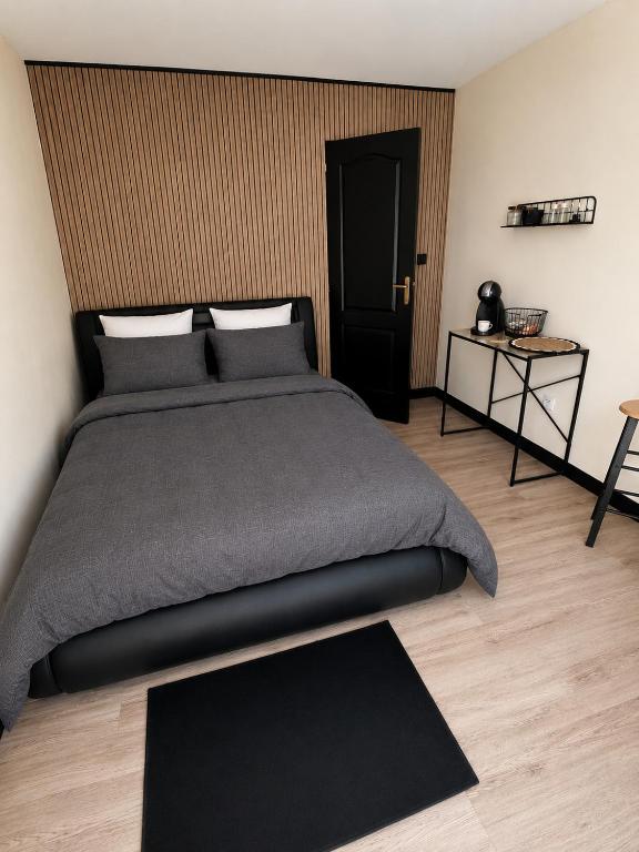 a bedroom with a large bed and a table at le nid gourmand in Andryes
