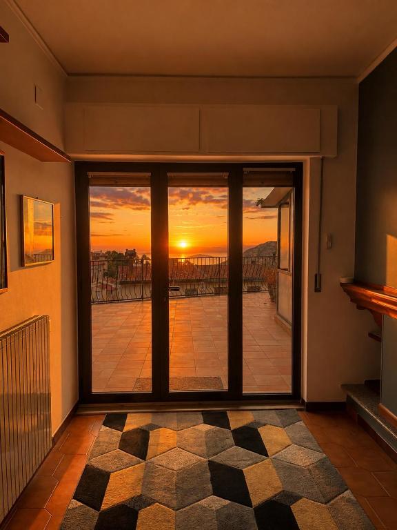 a room with a view of a sunset seen through glass doors at Sa Omu 'e Pinucciu in Lanusei