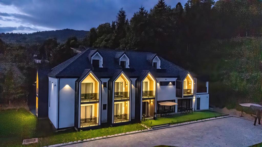 an aerial view of a house with its lights on at Mira Montis in Borşa