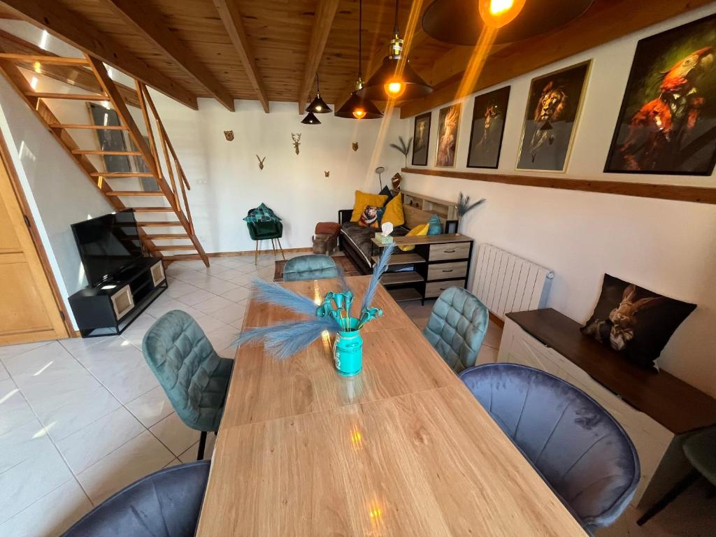 a dining room with a wooden table and chairs at Pets Home by Oxyne in Louches