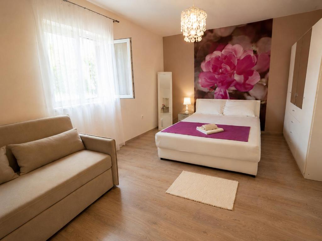 a bedroom with a large bed and a couch at Apartment Ivan in Marina