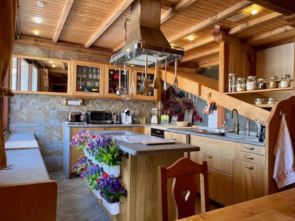 a kitchen with wooden cabinets and a kitchen island with flowers at Le grenier des rêves in Les Deux Alpes