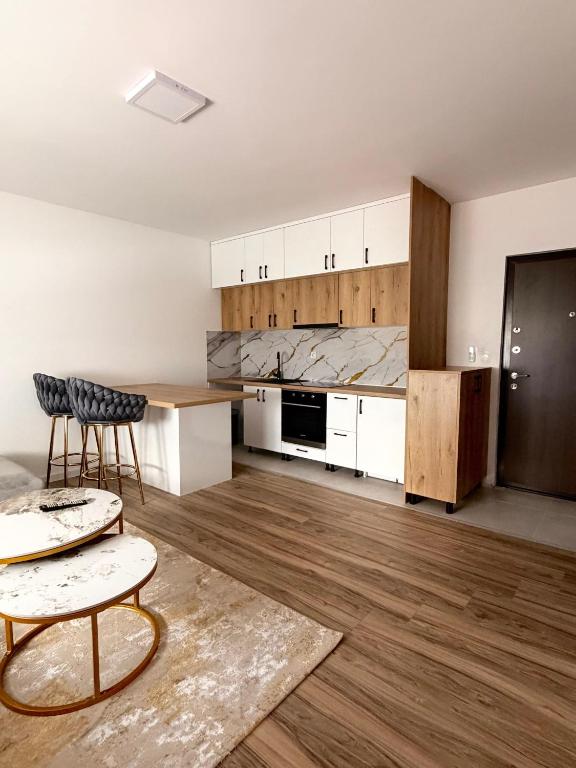 a kitchen with white cabinets and a table and chairs at Vila Šarić in Doglodi