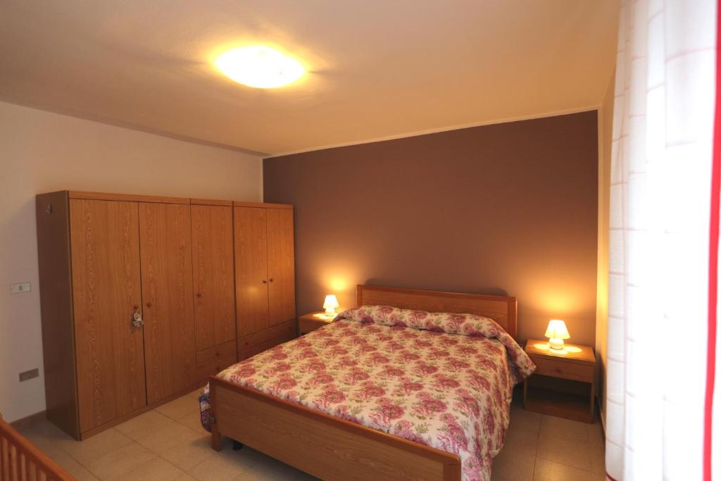 a bedroom with a bed and two lamps on two tables at Beauregard apartment in Aosta