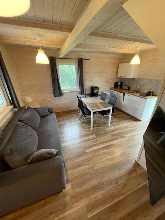 a living room with a couch and a table at Aurora - Domki całoroczne nad morzem w Dziwnówku in Dziwnówek