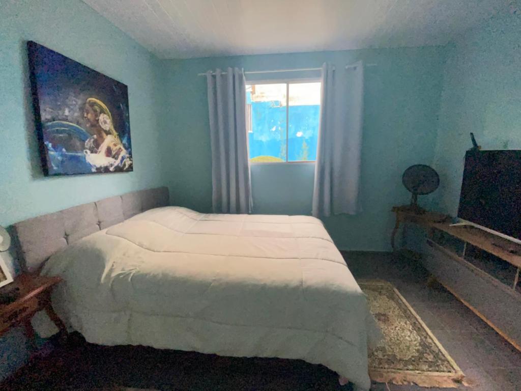 a bedroom with a white bed and a window at Loft Sousas in Campinas