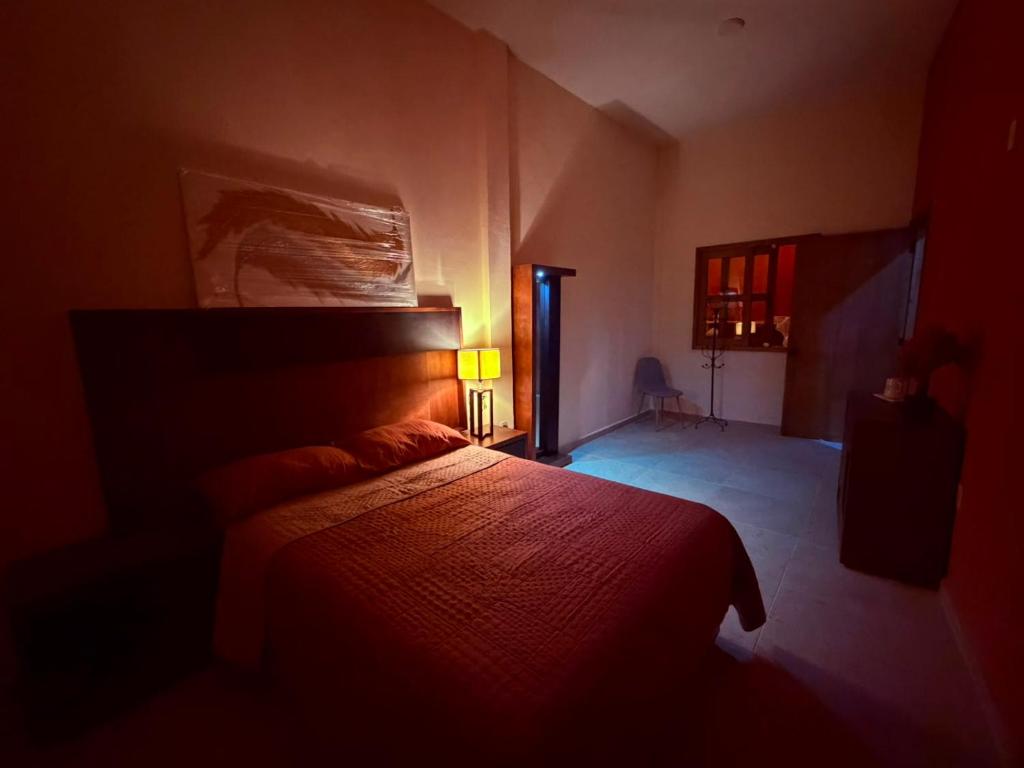a bedroom with a bed in a dark room at Hotel Estancia Bugambilias in San Diego de la Unión