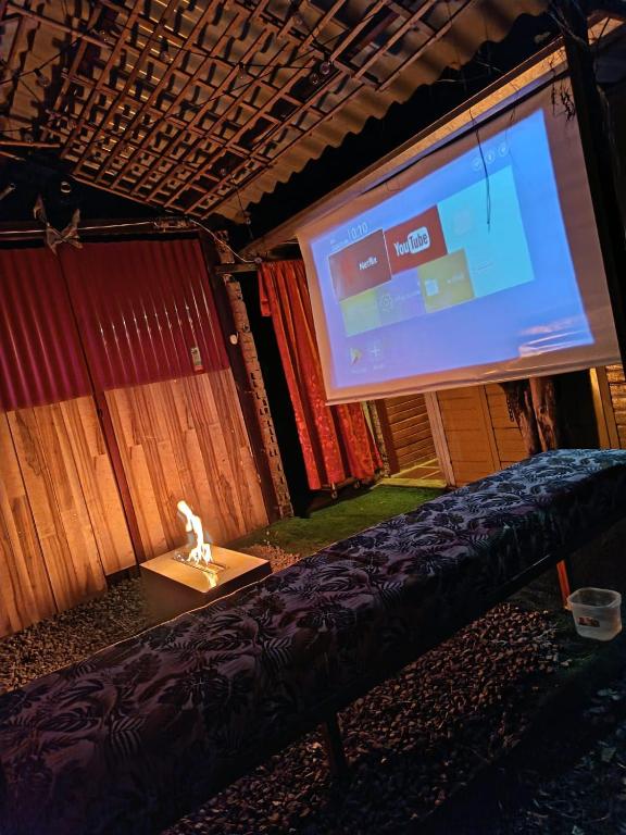a stage with a large screen and a couch at Altos de Shalem casa canaan in Anolaima