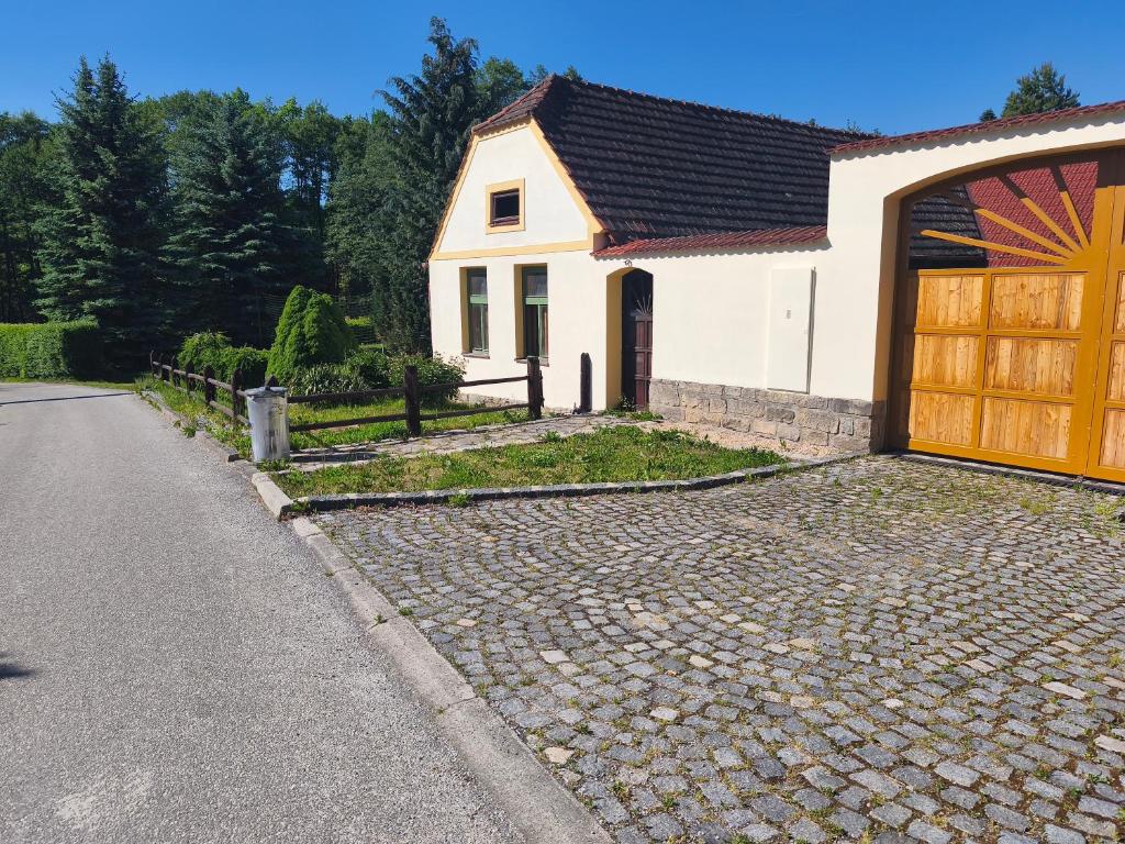 a white house with a door and a driveway at Pension V Doubí in Slavče
