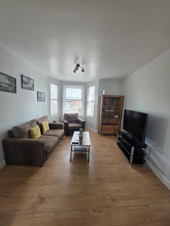 a living room with a couch and a tv at The Coastal Nest in Folkestone