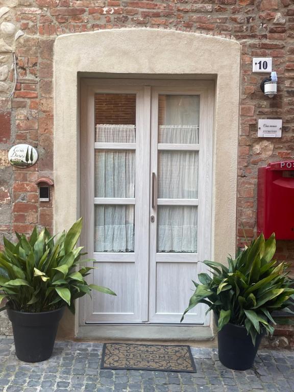 a door with two potted plants in front of a building at Casa Danesi in Monteleone dʼOrvieto