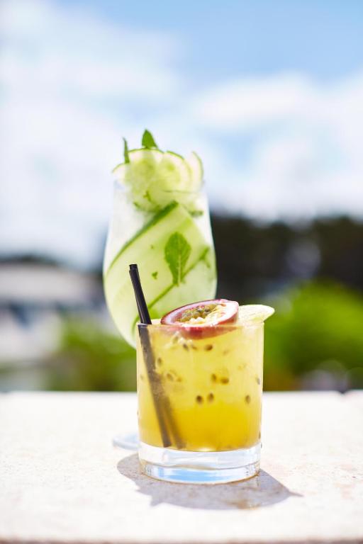 a drink on a table with a vase of flowers at St Moritz Hotel and Cowshed Spa in Polzeath