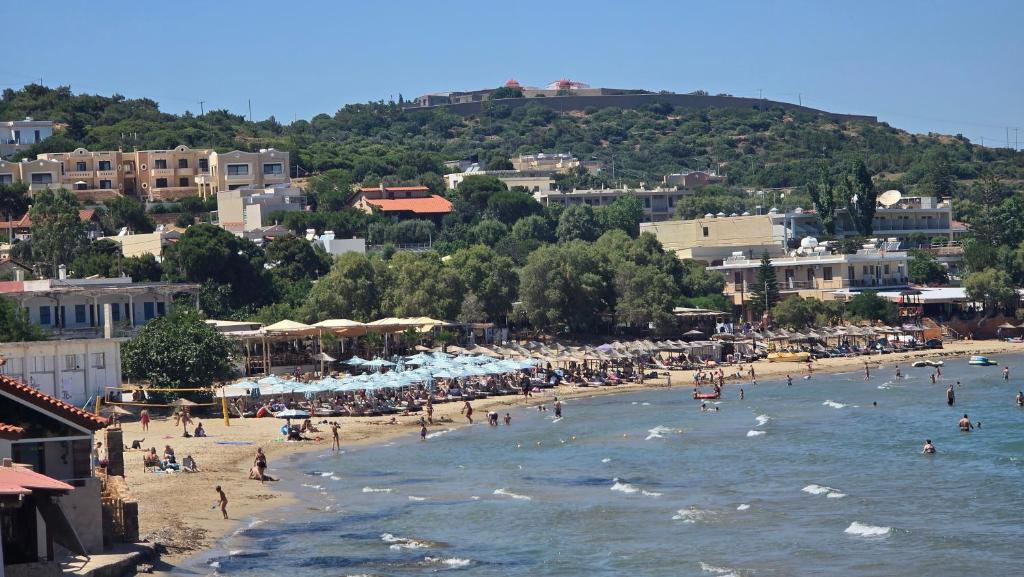 a beach with a bunch of people in the water at GLIPTIS Apartments in Chios