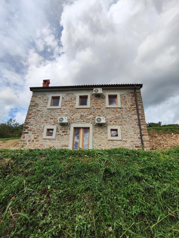 a brick building on top of a grassy hill at Roman Paradise Villa with Pool in Koper