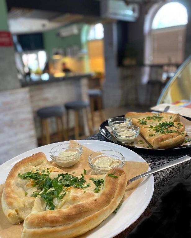 two pizzas sitting on plates on a table at ЭКО готель ,,Челентано ,, in Slavuta