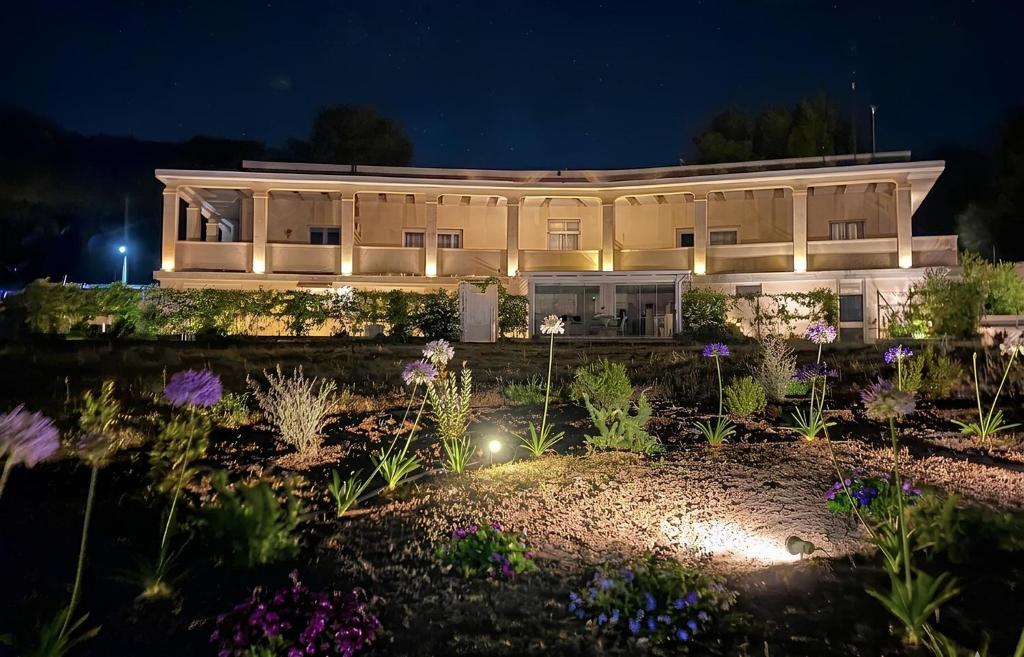 a building with a garden in front of it at night at Luna D'Argento in Leporano Marina