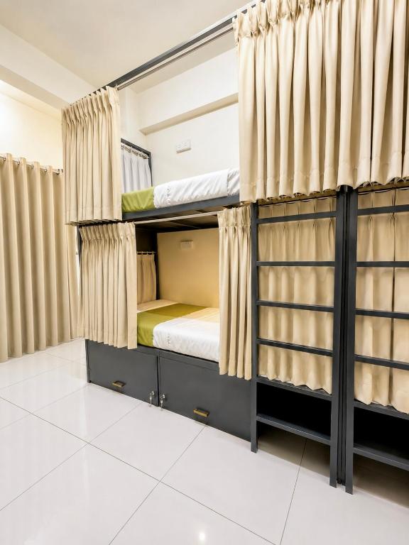 a bedroom with bunk beds with curtains at VELORA DORMs in Ujjain
