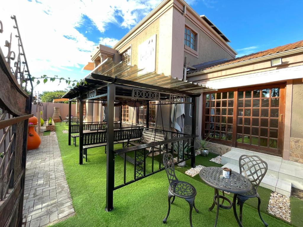 a patio with a table and chairs on the grass at Lady D Exclusive Abode in Polokwane