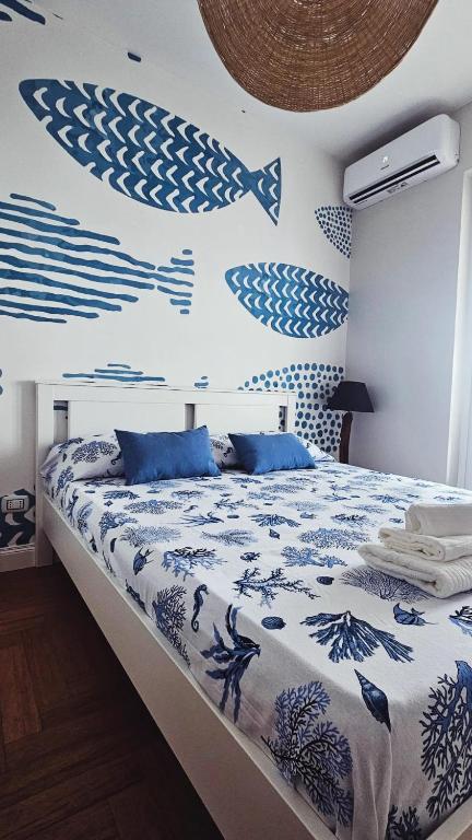 a bedroom with a bed and a wall with fish painted on it at Blu Marine Loano -Terrazza Vista Mare- in Loano