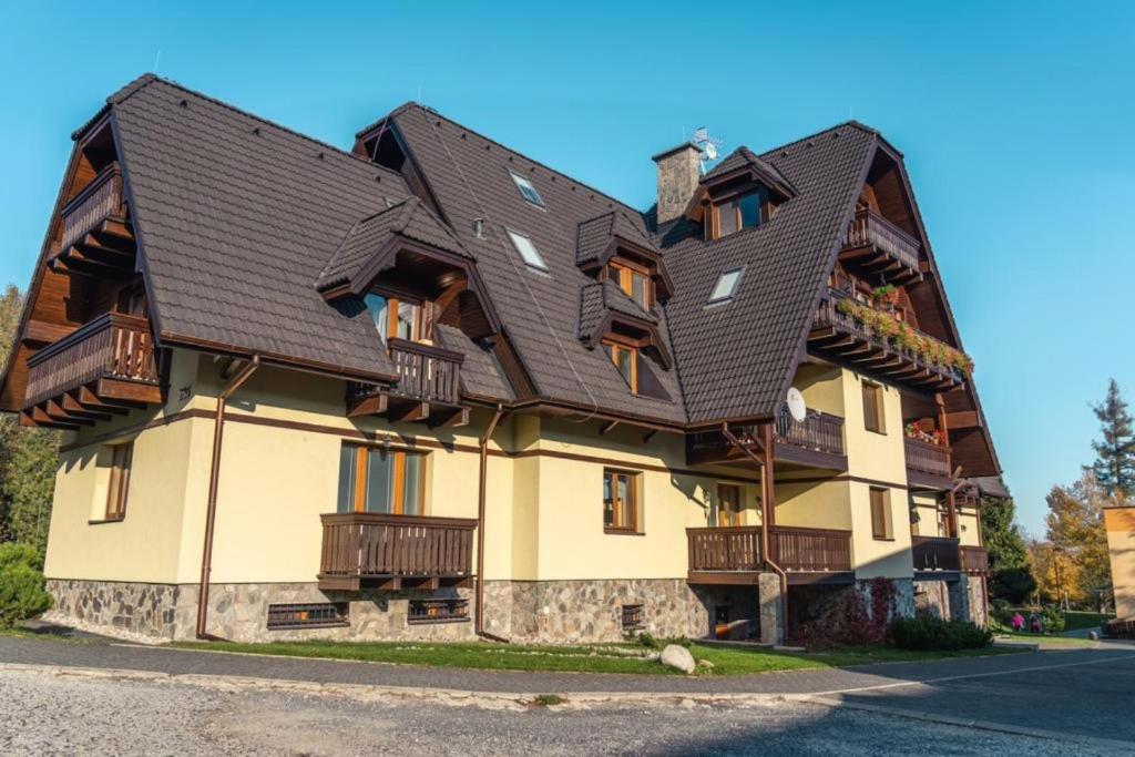 a large house with a gambrel roof at Lomnica Orange Apart in Tatranská Lomnica
