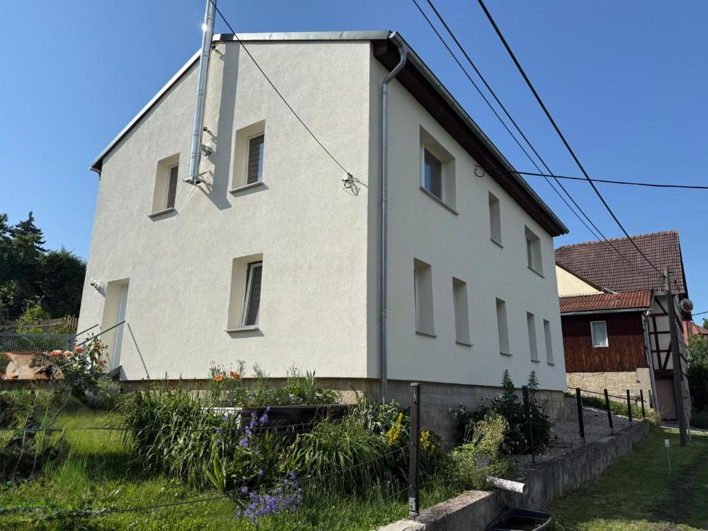 a white house with a cross on the side of it at Ferienwohnung am Gothewanderweg in Schwarza