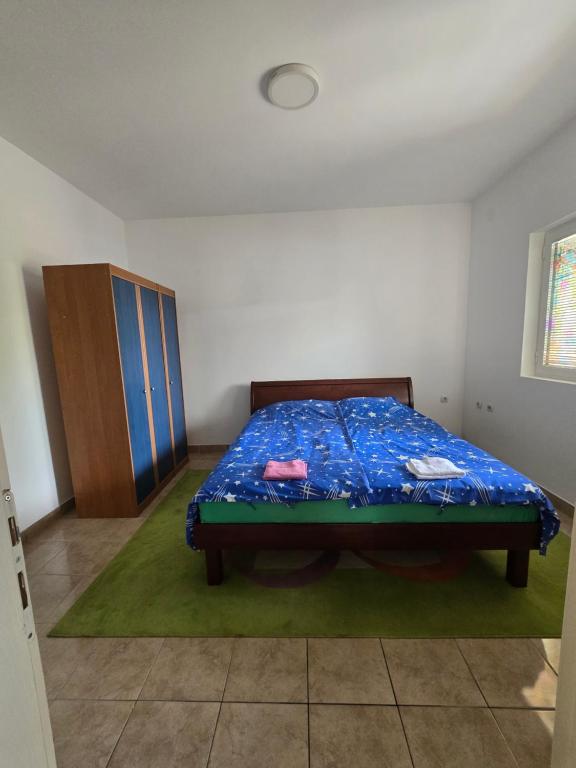 a bedroom with a bed and a wooden cabinet at Nin Apartman Free Parking in Kaluđerica