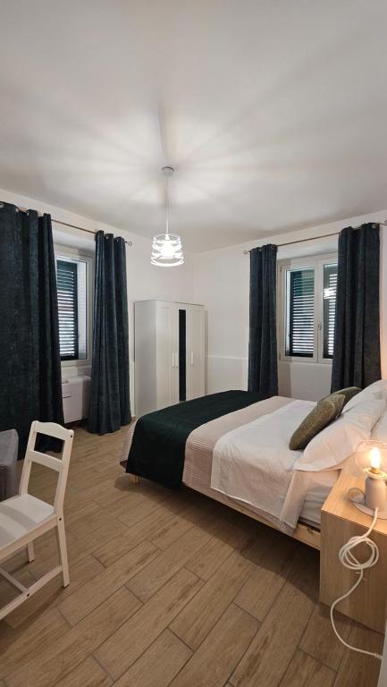 a bedroom with a large bed and a chair at Mare Apartment in Nocera Inferiore