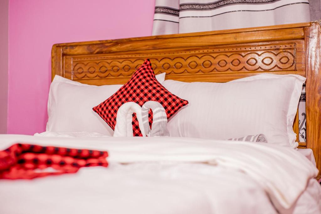 a person laying on a bed with a red and white pillow at Olivia Green Lodge in Arusha