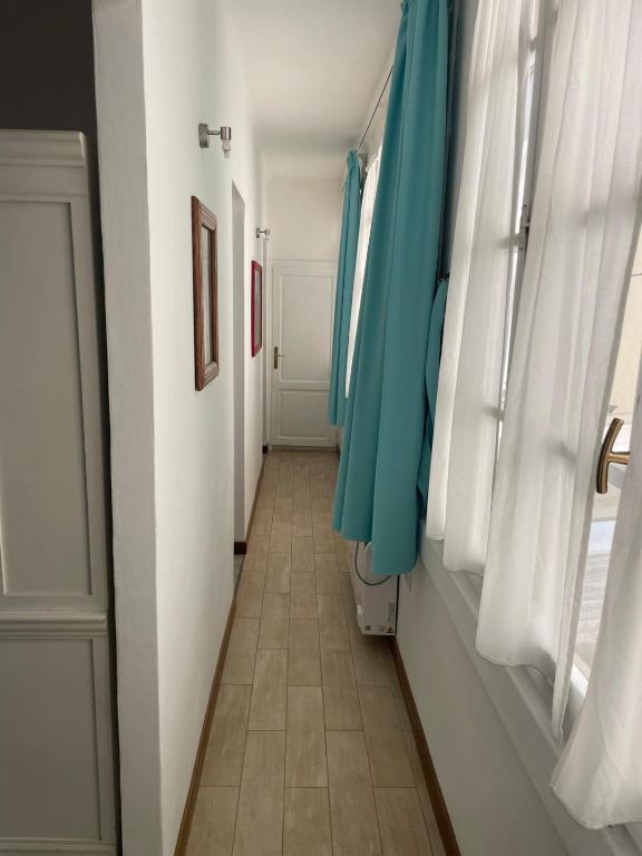 a hallway with blue curtains and a tile floor at Smartop Apartment in Forte dei Marmi