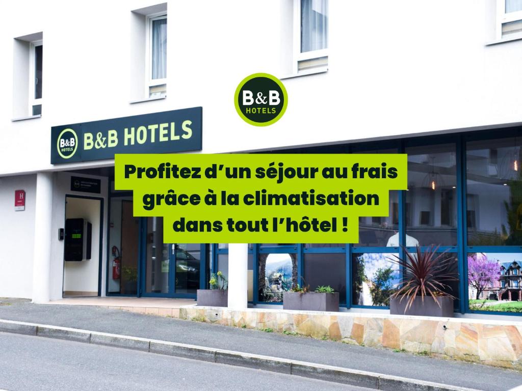 a store with signs on the front of a building at B&B HOTEL Rodez Bourran in Rodez