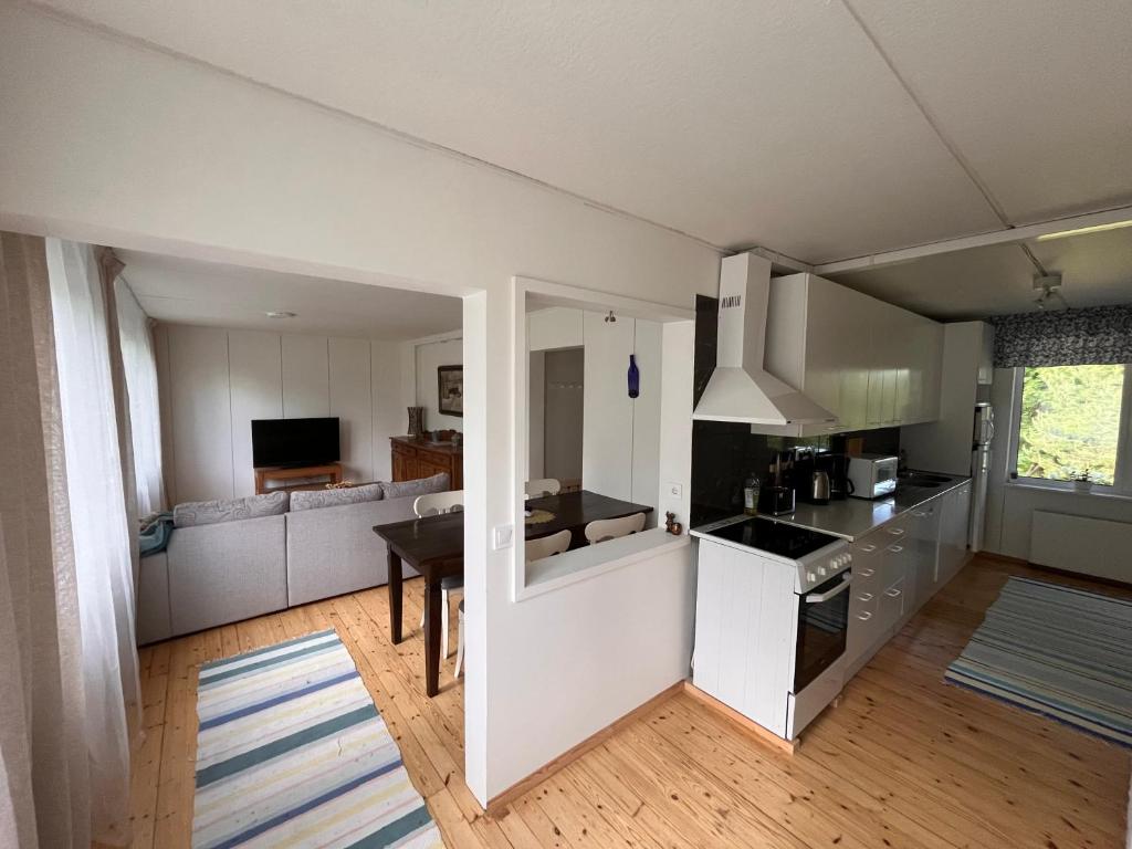 a kitchen and living room with a table and a couch at Juurikkalahti Adventure Center in Kajaani
