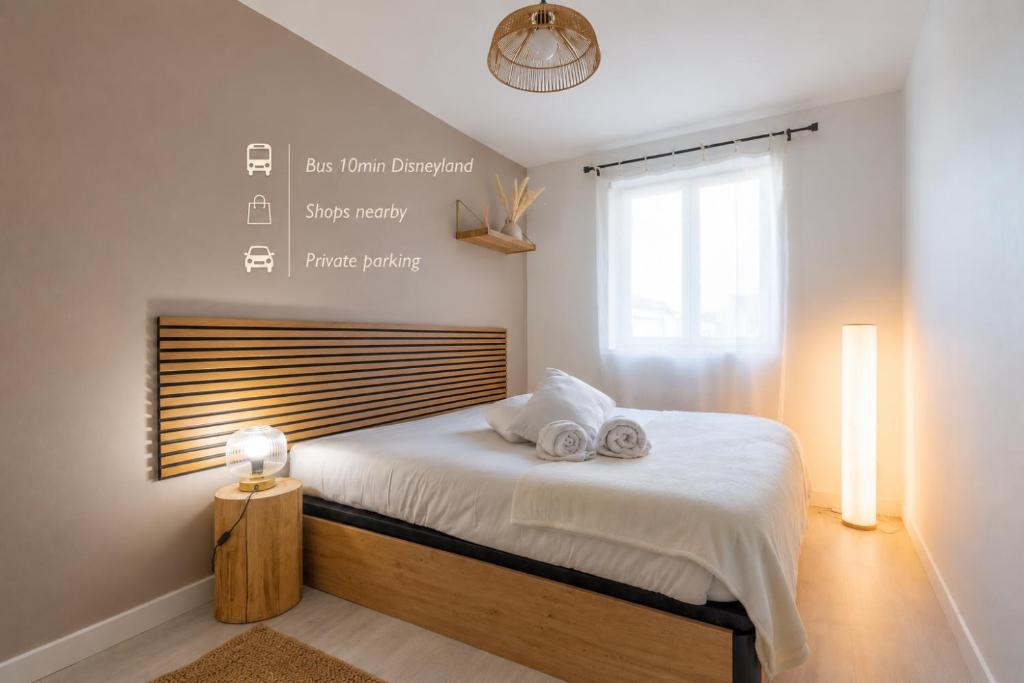 a bedroom with a bed with two towels on it at Cocon magique - 10min Disneyland parking privé idéal famille in Coupvray