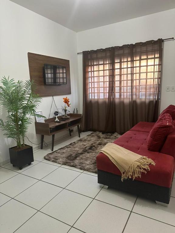 a bedroom with a red bed and a desk at Ap 07 mazzonetto in Primavera do Leste