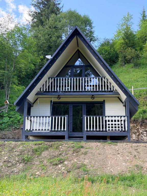 a house with a gambrel roof with a porch at Подих Свободи in Sloboda