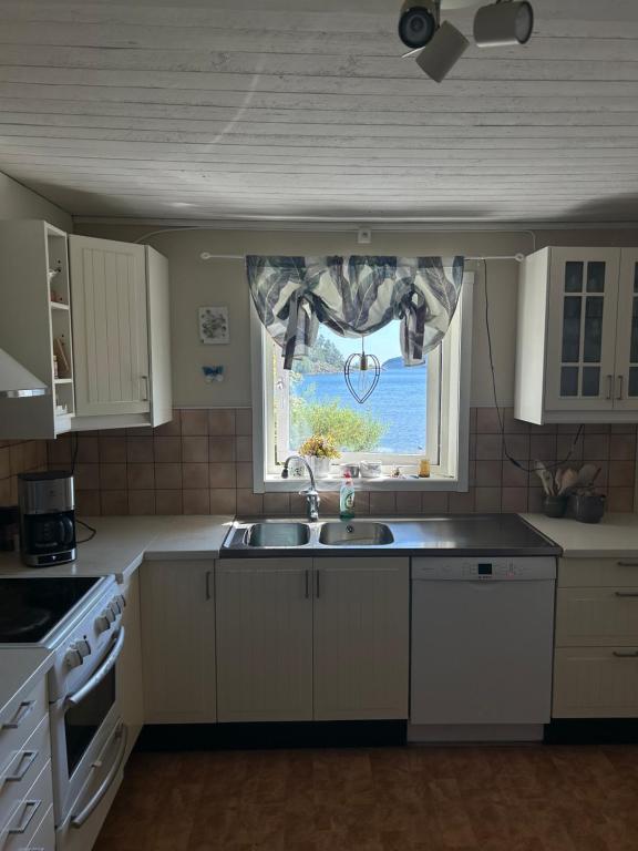 a kitchen with a sink and a window at Höga kusten Berghamn in Noraström