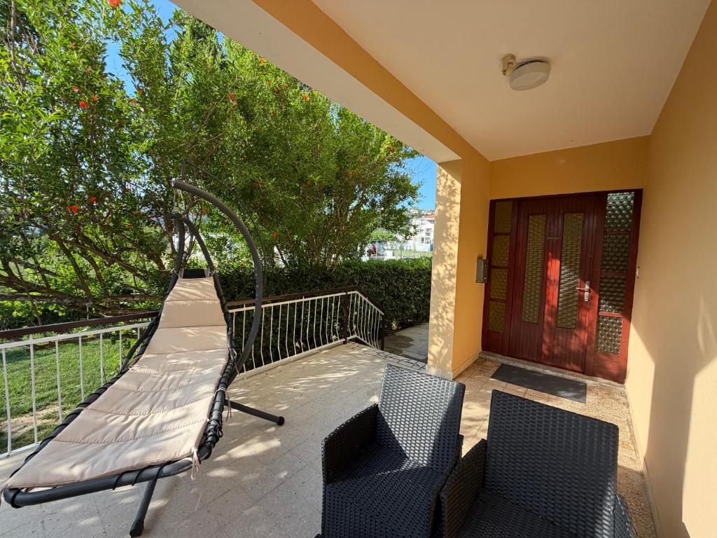 a porch with two chairs and a swing at Studio Apartmani ISRA in Palit