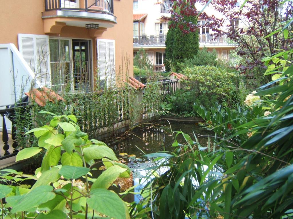 einen Garten mit einem Teich vor einem Gebäude in der Unterkunft Ferienwohnung LAGUNA-Residenz am Meer/ Whg. 29 in Kühlungsborn