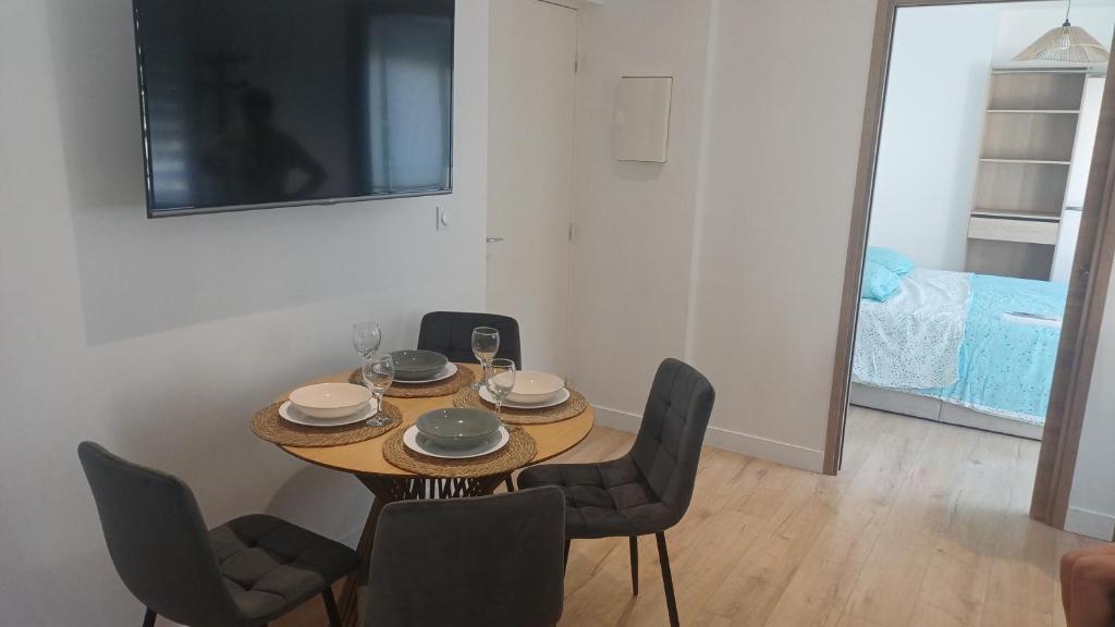 a dining room table with chairs and a television at Appartement lena in Boulogne-sur-Mer