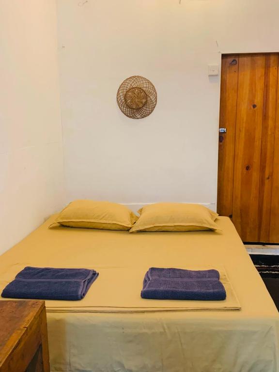 a bed in a room with two pillows on it at Arugam Bay Beach House in Pottuvil
