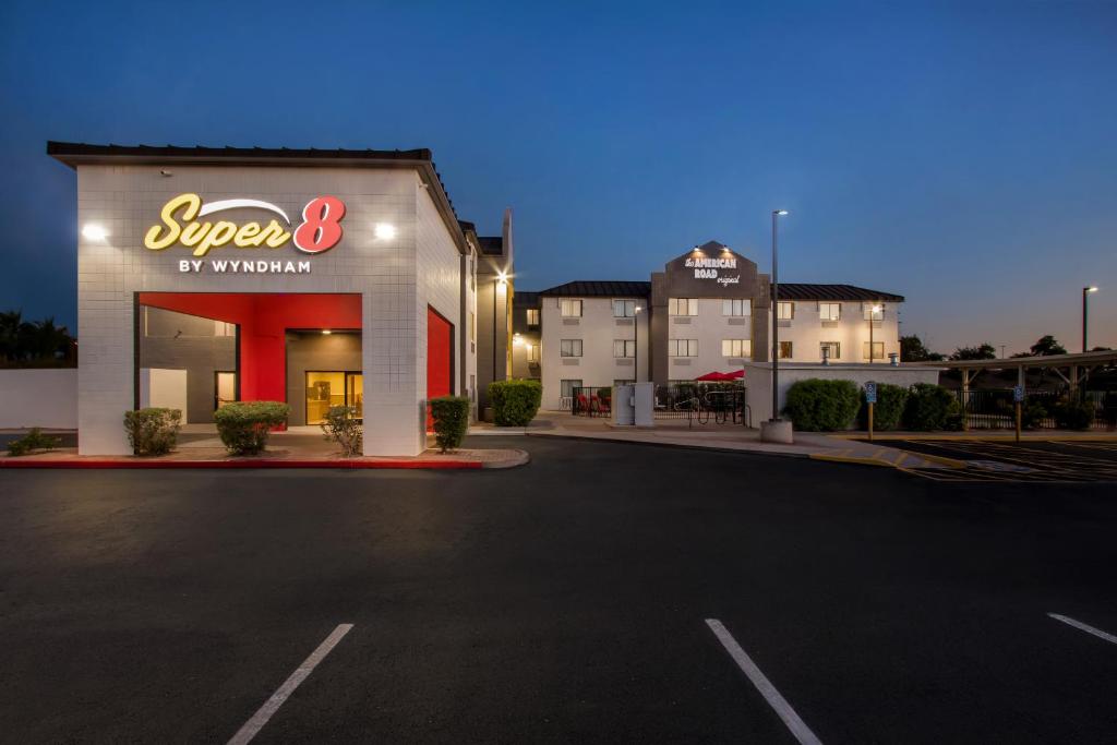 a store with a lit up sign in a parking lot at Super 8 by Wyndham Mesa Gilbert in Mesa
