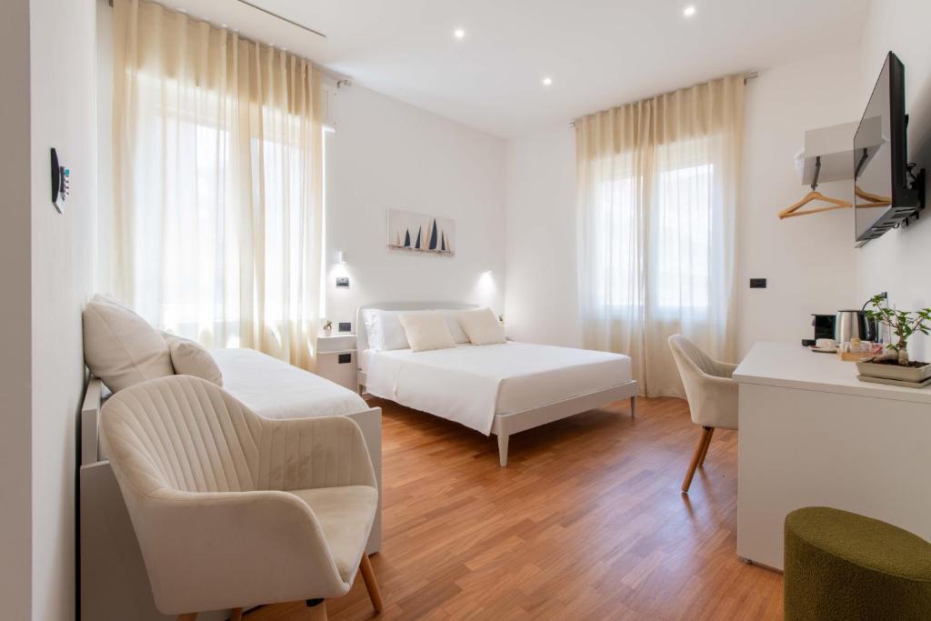 a white bedroom with a bed and a desk at Lumen Boutique Stay in Naples