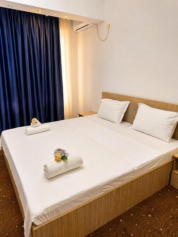 a bedroom with a large bed with towels on it at Villa Italia Boutique in Mamaia Sat/Năvodari