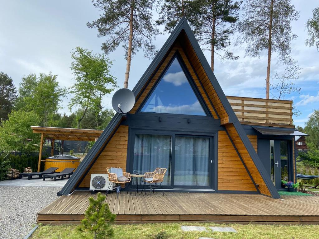 a tiny house with a large window on a deck at Markowa Przystań in Ożenna