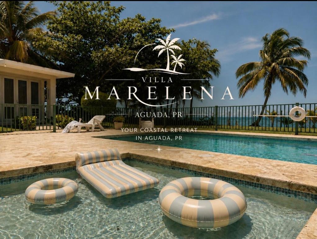 a swimming pool with two chaise lounges in the water at Villa Marelena Beachfront Villa Aguada Near Rincón in Tablonal