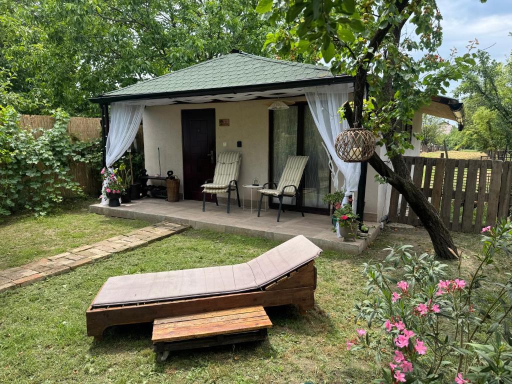 a gazebo with a bench and a table in a yard at Danguba 5 in Nova Pazova