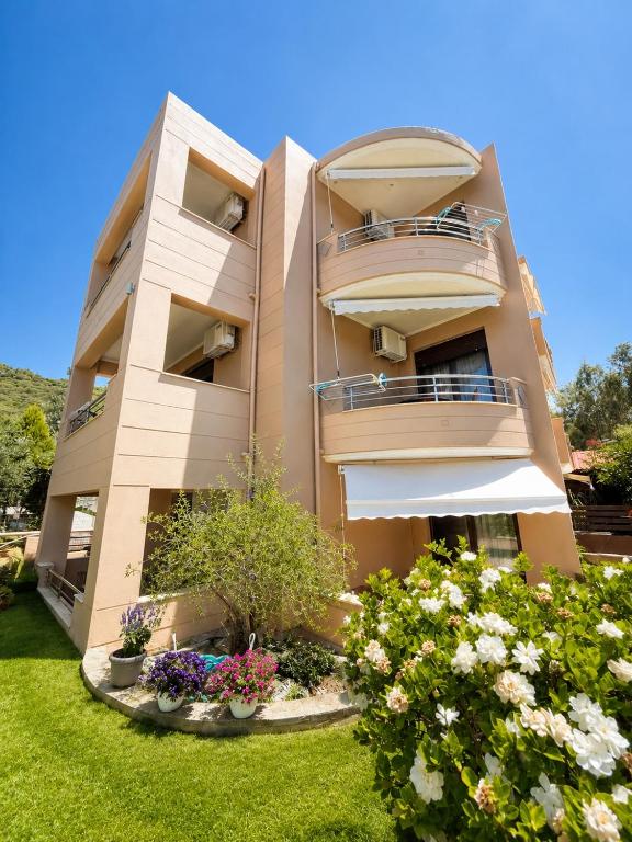a building with balconies and flowers in a yard at Studios Galini Porto Koufo in Porto Koufo