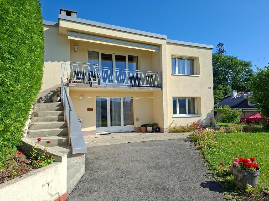 a house with a balcony and stairs in front of it at Villa panorama 1000 in La Chaux-de-Fonds